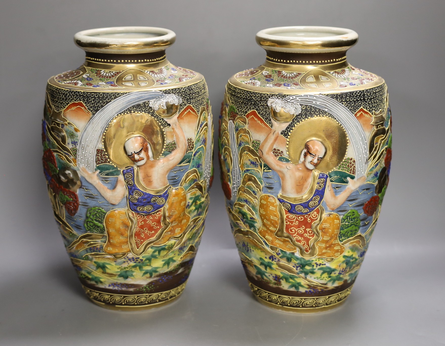 A pair of Japanese moulded and moriage decorated vases, 31cms